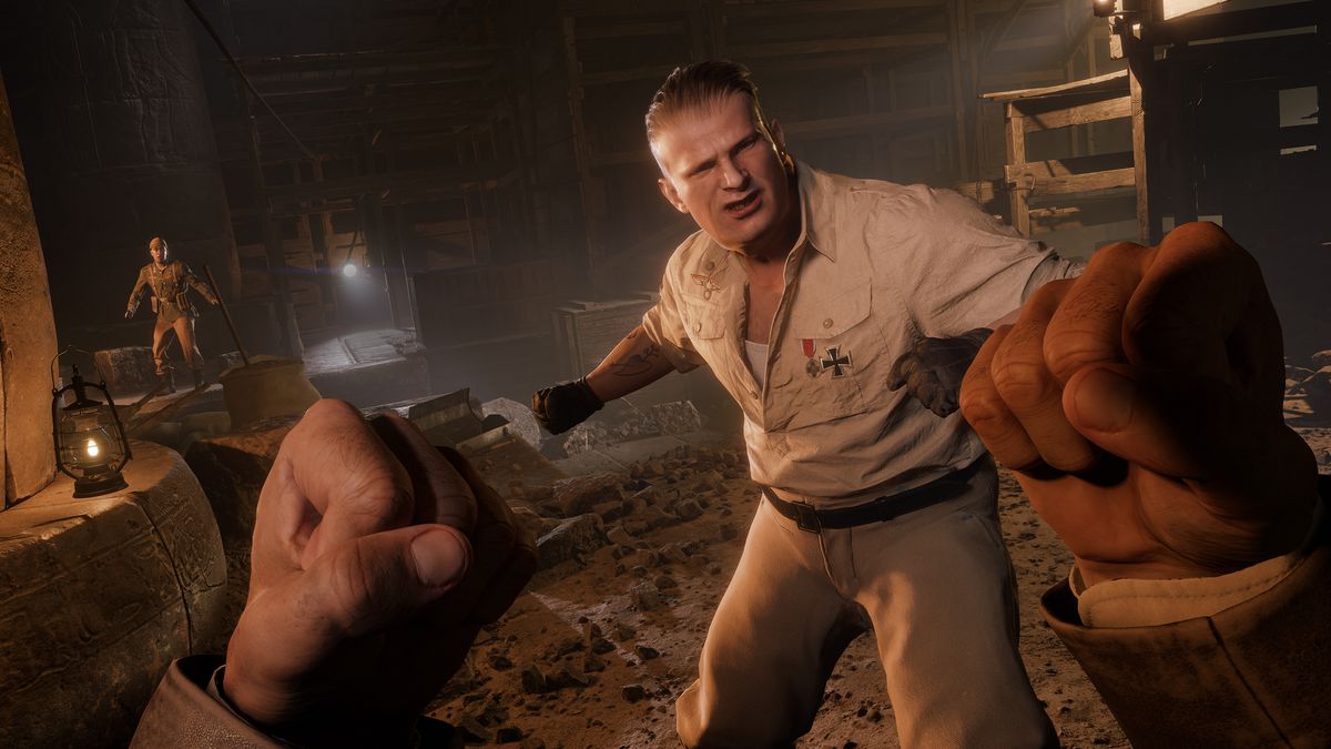 A first-person view from Indiana Jones’ perspective, with his fists raised as he battles a Nazi soldier in an underground mine from the game Indiana Jones and the Great Circle