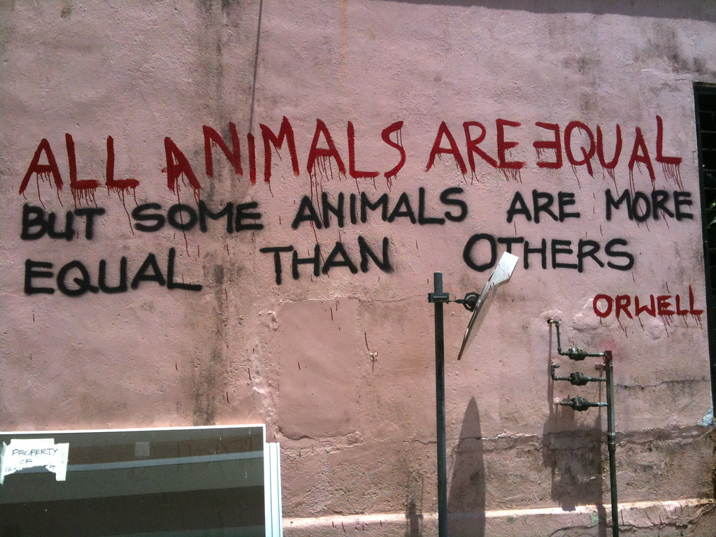 Graffiti text saying "All animals are equal but some animals are more equal than others"