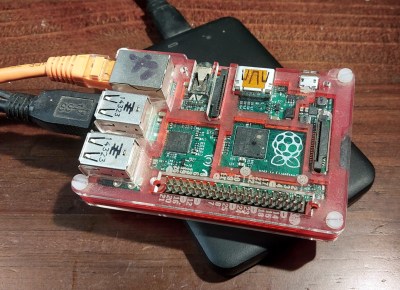A raspberry Pi model b sitting on top of a USB hard drive enclosure