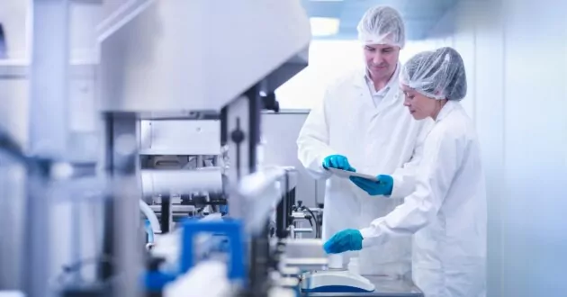 Lavoratori che ispezionano lo sviluppo del prodotto in una fabbrica farmaceutica
