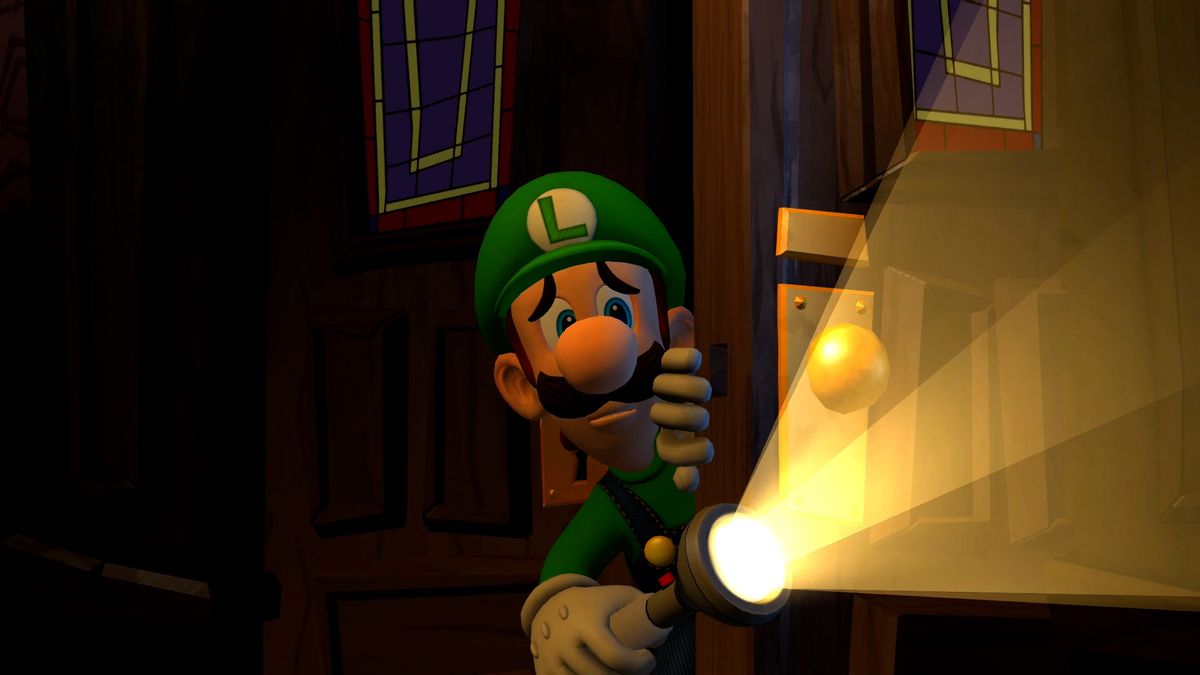Korkmuş bir Luigi, Luigi's Mansion 2 HD'de bir kapının arkasından bakıyor ve el fenerini parlatıyor
