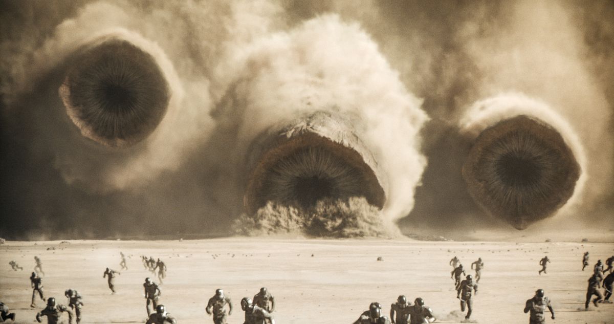 Tre massive sandorme rykker frem på flygtende mennesker i Dune 2