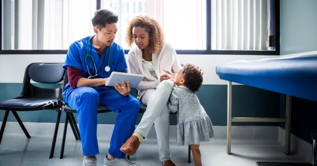 护士在医院里向幼儿展示数字平板电脑