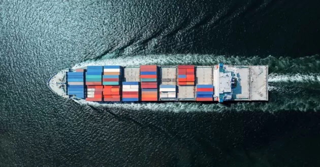 Aerial view of ship with shipping containers moving through water