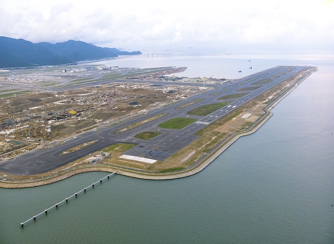 «Международный аэропорт Гонконга расширяет пропускную способность за счет системы с тремя взлетно-посадочными полосами, завершение строительства запланировано на 2024 год.