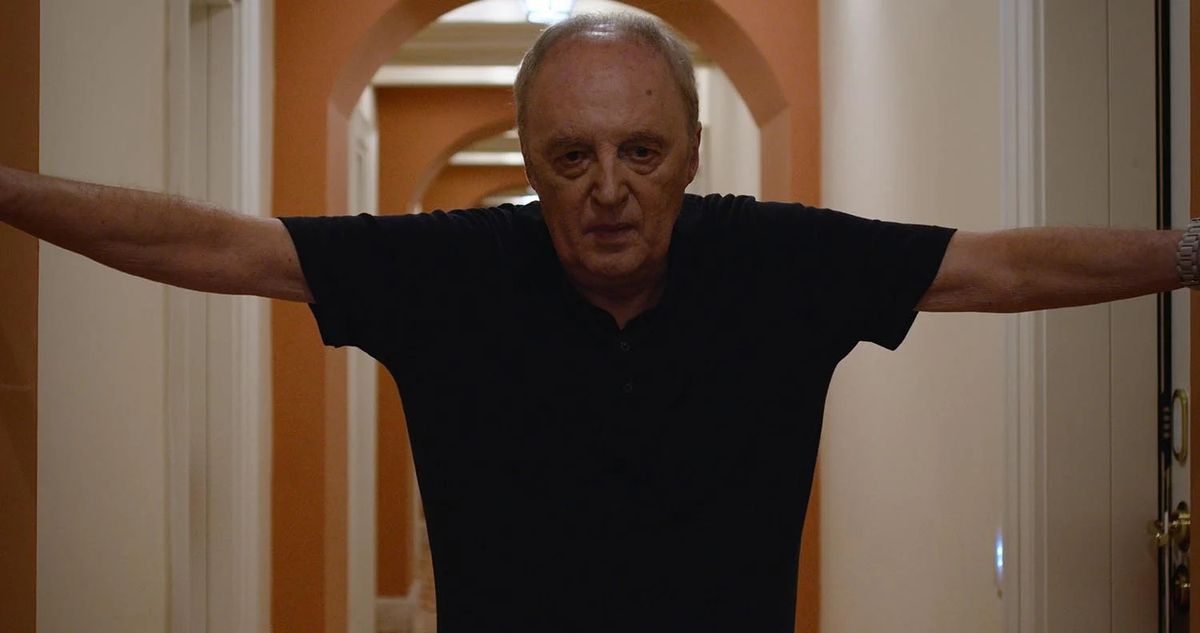 Dario Argento standing in a hallway with his hands pressed against the walls in Dario Argento: Panico